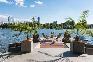 uma vista para um lago com cadeiras e palmeiras em AJO Vienna Beach - Contactless Check-in em Viena