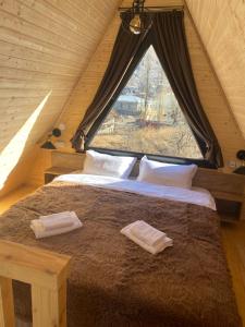 ein großes Bett in einem Zimmer mit Fenster in der Unterkunft Cottages LIZA in Kazbegi