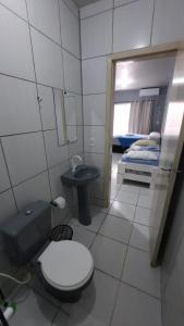 1 cama y baño con aseo y lavamanos. en ZZZ BRUNO KLEMTZ - Residencial Recanto dos Pássaros Estúdio até 4 pessoas com ar Split wifi coz vaga, en Itapema