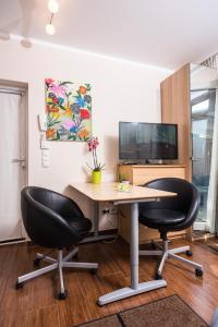een kantoor met 2 stoelen, een bureau en een tv bij AJO Vienna Beach - Contactless Check-in in Wenen