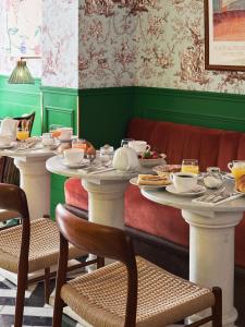 een eetkamer met twee tafels met gerechten erop bij Hôtel Les Deux Gares in Parijs