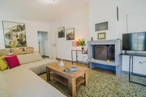 sala de estar con sofá y chimenea en Green Apartment ground floor feel like home properties, en Saronida