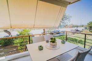 - Balcón con mesa blanca y sillas en Green Apartment ground floor feel like home properties, en Saronida