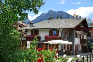 a house with flowers and an umbrella in front of it at Chalet Gardenia in Bormio