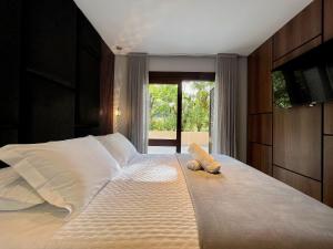 1 dormitorio con 1 cama grande y ventana grande en Apartamento Morada dos Tucanos 1 dorm by Achei Gramado, en Gramado