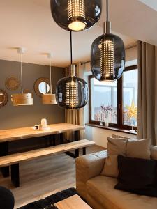 Luxury Apartments Panorama في دونوفالي: غرفة معيشة بها أضواء قلادة وأريكة