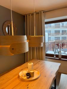 Luxury Apartments Panorama في دونوفالي: طاولة خشبية عليها لوحة و كوبين