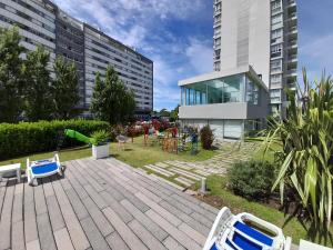 een patio met stoelen en een speeltuin voor een gebouw bij Bellagio Tower in Punta del Este