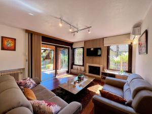 uma sala de estar com um sofá e uma mesa em Casa Allegro 3dorm prox Lago Negro by AcheiGramado em Gramado