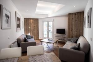 a living room with two couches and a tv at Bed and Snow Art Apartments in Sierra Nevada