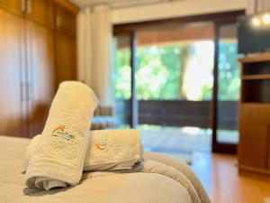 um par de toalhas sentadas em cima de uma cama em Casa Allegro 3dorm prox Lago Negro by AcheiGramado em Gramado
