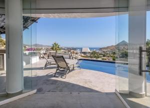 a patio with chairs and a view of the ocean at The one and only Pedregal Hollywood House in Cabo San Lucas