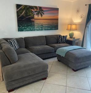 a living room with a couch and a ottoman at Bright and Beachy 2Bed 1Bath Home - Unit 210 in Cocoa Beach