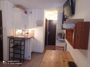 una pequeña cocina con una mesa de madera en una habitación en Super appartement T2 au pieds des pistes., en Les Deux Alpes