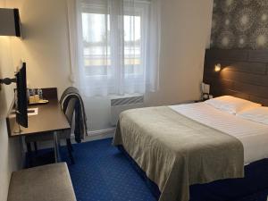 a hotel room with a bed and a desk and a window at The Originals City, Hôtel du Château, Pontivy (Inter-Hotel) in Pontivy