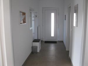 a hallway with white walls and a white door at FeWoMeißner in Wittingen