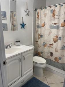 uma casa de banho com um lavatório, um WC e uma cortina de chuveiro. em Bright and Beachy 2Bed 1Bath Home - Unit 210 em Cocoa Beach
