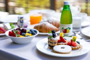 una mesa con un plato de comida y una botella de zumo en Wine Hotel Retici Balzi, en Poggiridenti