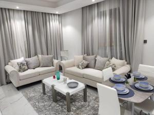 a living room with two couches and a table at Al Safwa One in Al Ḩadd