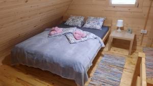 a bedroom with a bed with two pink slippers at Brvnare Borove iglice in Vinci