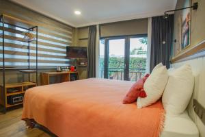 a bedroom with a bed with an orange blanket and a window at Istanbul Old City Colorful Houses Balat PETRION Hotel in Istanbul