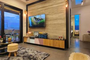 a living room with a tv on a wall at Casa NovPool perfect for families in Nov