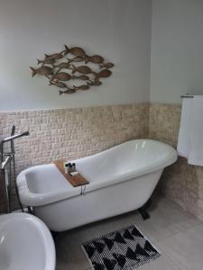 Off Shore Ballito في باليتو: حوض استحمام أبيض في حمام مع مرحاض