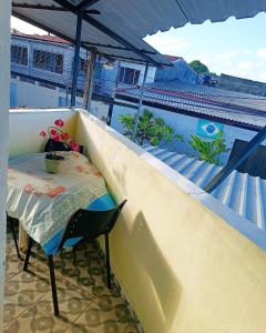 a table and a chair on a balcony with a view at Hospedaria in Recife