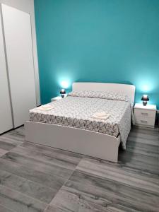 1 dormitorio con cama y pared azul en Naxos Room, en Giardini Naxos