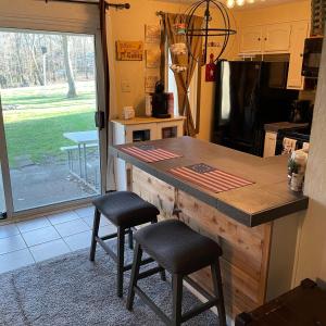 une cuisine avec un comptoir avec deux tabourets et une table dans l'établissement Blue Knob Bear Den (Nordic Center/Golf Course), à Claysburg