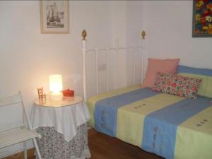 a bedroom with two beds and a table with a lamp at La Villa, Alojamiento Rural in Iznájar