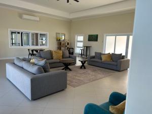 Sala de estar con 2 sofás y mesa en Seamist villa @Oceanpointe Lucea comfy 2BR w/pool gym & parking, en Lucea
