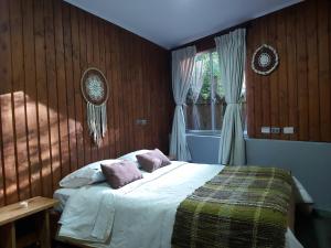 En eller flere senge i et værelse på Hostal Ruka Lodge
