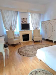 1 dormitorio con 1 cama, 2 sillas y chimenea en Vila Micul Castel, en Sinaia