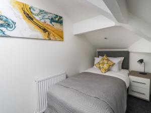 1 dormitorio con 1 cama y una pintura en la pared en Mill Hey, en Keighley