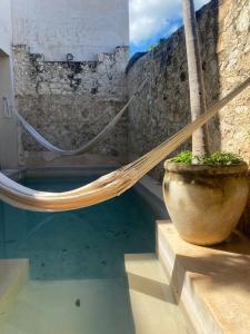 a hammock in a pot next to a pool of water at hotel xucum in Campeche