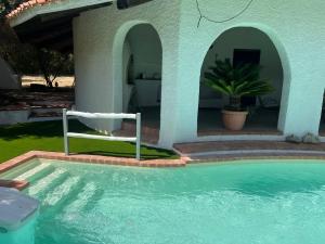 a pool with a chair next to a house at Casale al mare - villa with swimming pool 150 meters from the beach in Porto Columbu - Perdʼe Sali +68 photos