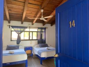 a room with two beds and a blue door at MayFlower Hotel & Hostal in Puerto Escondido +72 photos