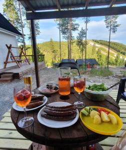 a wooden table with plates of food and drinks at Stuga i Storklinten in Harads
