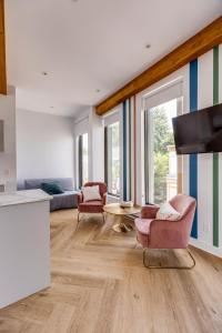 a living room with two chairs and a tv at Le Virtuose - Vieux-Terrebonne in Terrebonne