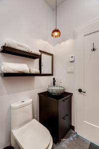 a bathroom with a toilet and a sink and a mirror at Le Virtuose - Vieux-Terrebonne in Terrebonne