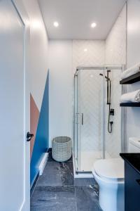 ein Bad mit einer Dusche und einem WC in der Unterkunft Le Virtuose - Vieux-Terrebonne in Terrebonne