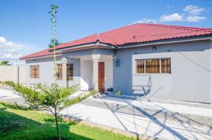 ein weißes Haus mit rotem Dach in der Unterkunft Carsi holiday Villa in Lusaka
