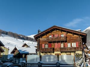 um grande edifício de madeira com uma varanda numa pista de esqui em Camana Veglia em Livigno