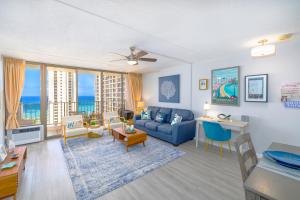 Waikiki Upscale 1 BR - Ocean Views - Parking في هونولولو: غرفة معيشة مع أريكة زرقاء وطاولة
