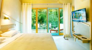 1 dormitorio con 1 cama, TV y patio en Villa Rossa en Parga