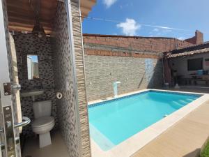 a swimming pool in a house with a toilet at Casa Praia dos Milagres-3suítes-piscina-850m da praia in São Miguel dos Milagres