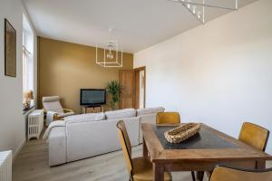 a living room with a white couch and a table at Gîtes in Huy - Appartements chaleureux dans le centre de Huy in Huy