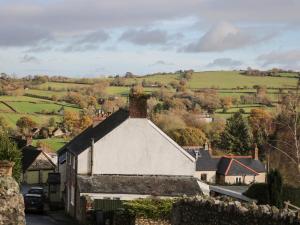 an old house in a small village with a hill in the background at Ambleside in Chard