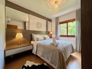 1 dormitorio con cama, escritorio y espejo en Apartamento Aroma da Serra 2 dorm by Achei Gramado, en Gramado